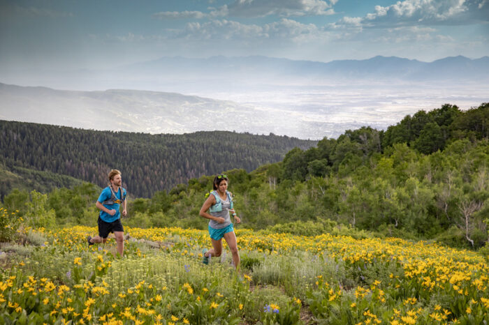 Couple trail running in the Wastach Mountains, Davis County, Utah.